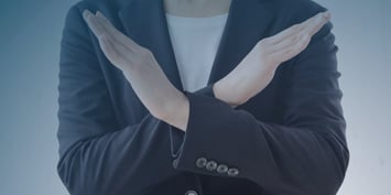 A woman in a business suit makes a hand gesture, illustrating key points about declining job offers in a professional context.