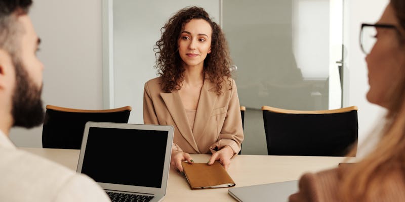 Woman in a job interview being interviewed by two people