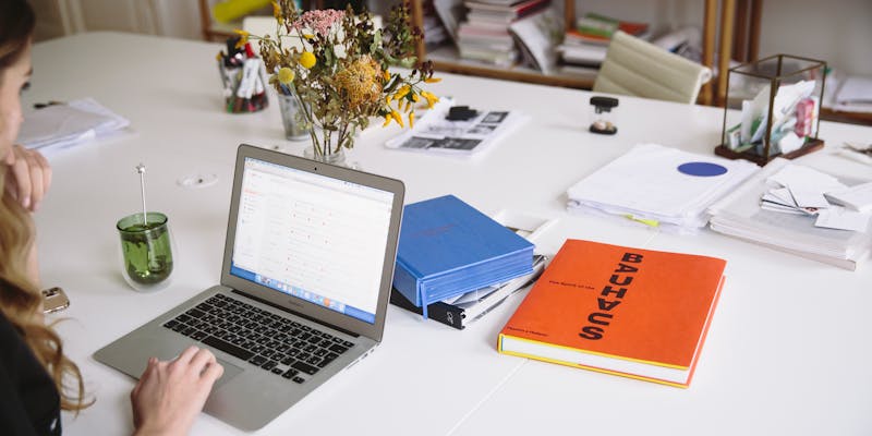 woman at her desk working on a laptop
