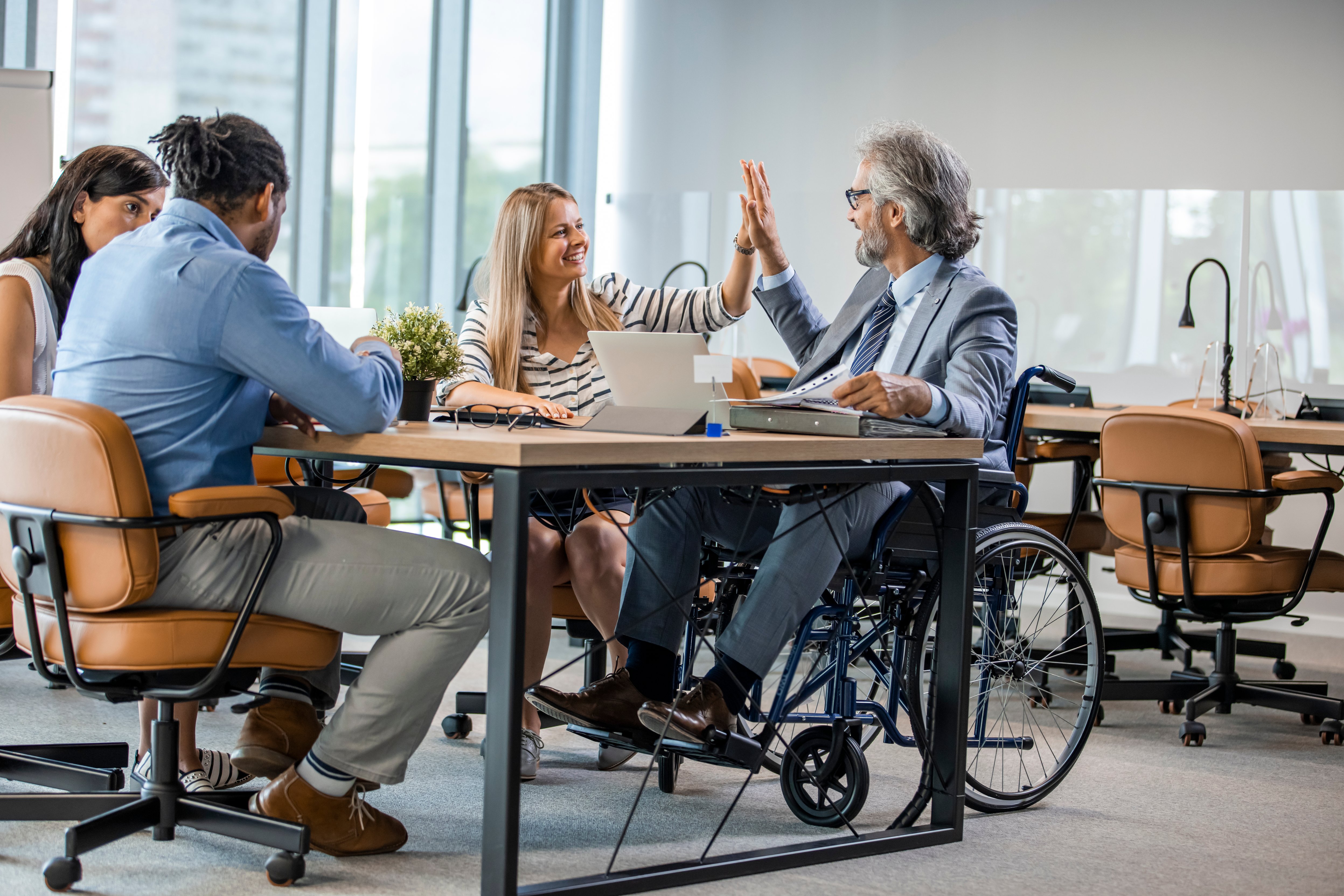 Colleagues high-fiving in an office in Germany