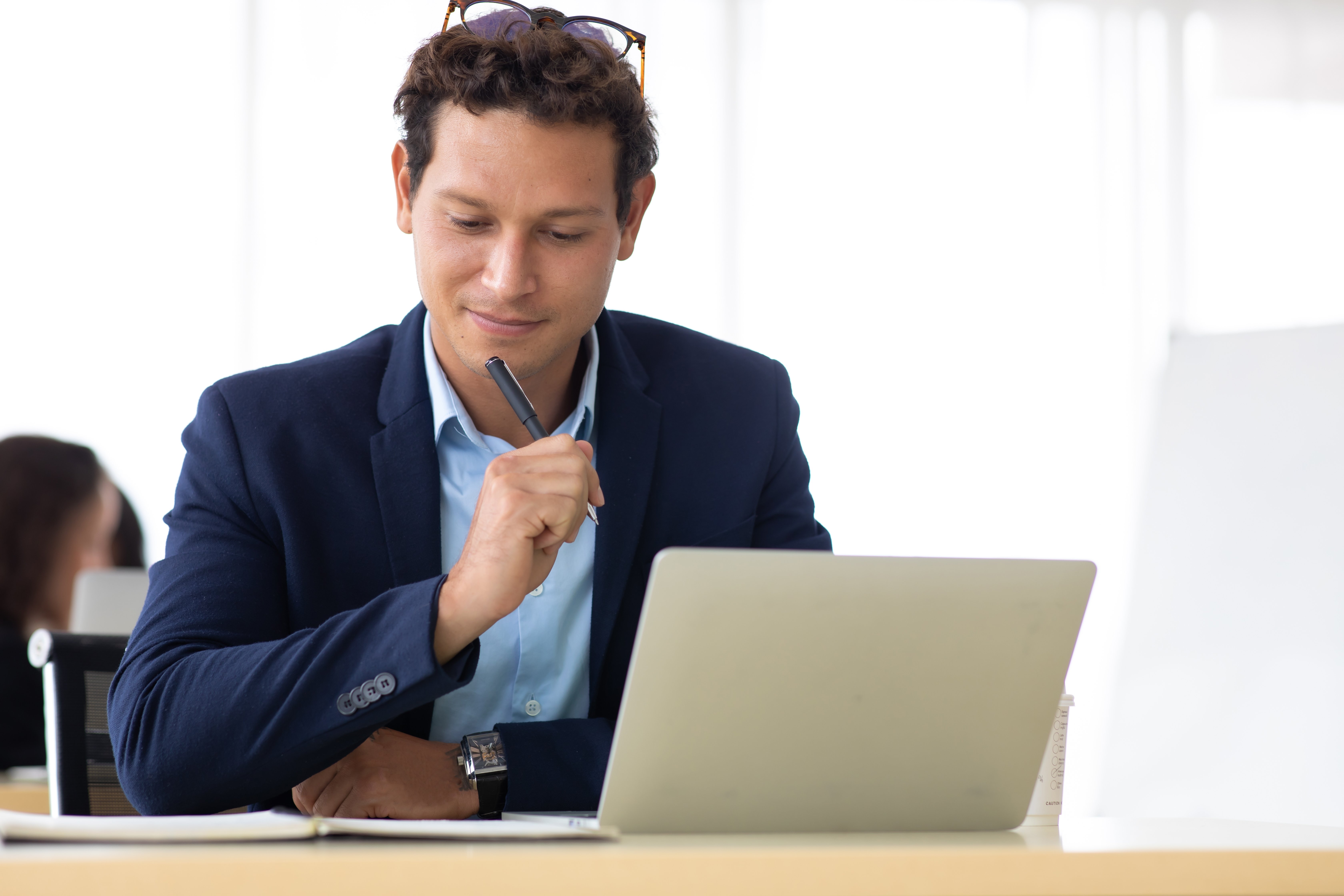 Man thinks about a work project in front of a laptop