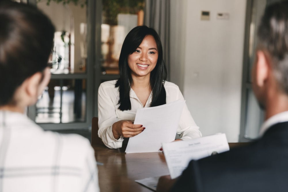 woman in an office setting being interviewed by two people
