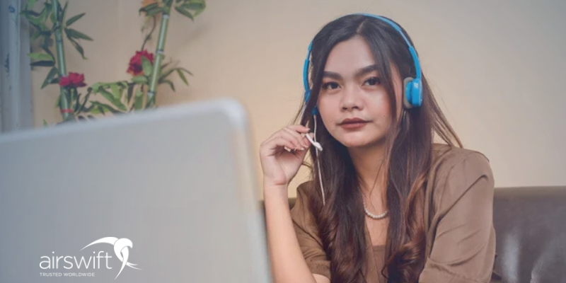Young Gen Z woman with long dark hair wearing a headset and participating in a virtual meeting