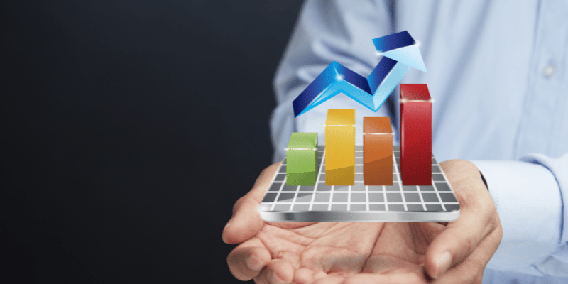 Hands holding up a 3-D holograph of an upward trending graph