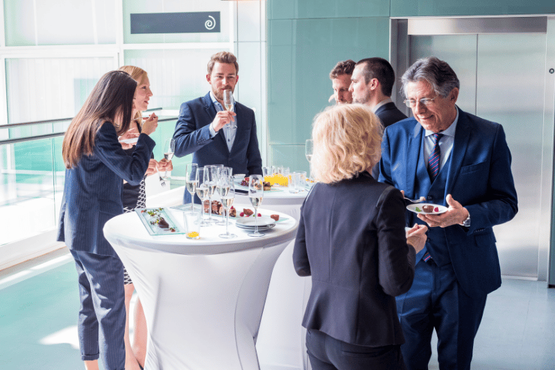 People gathered around a refreshments table engaging with each other