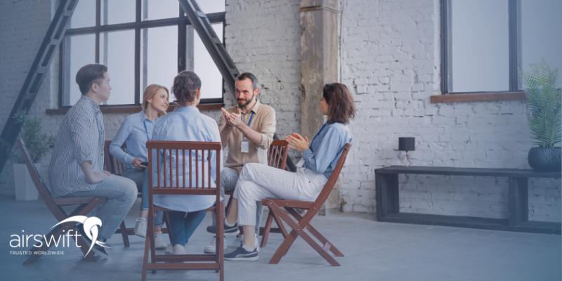 A group of individuals sitting in a circle having a discussion