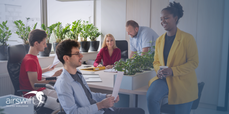 An inclusive work environment in which a group of individuals engage in a productive conversation, their expressions are happy